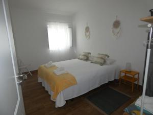 a white bedroom with a white bed and a window at Quinta do Freixo in Elvas