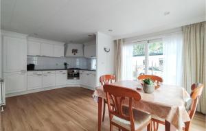 een keuken met een tafel en stoelen en een keuken met witte kasten bij Nice House In Putten in Putten