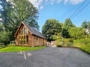 a log cabin with a parking lot in a driveway at Swn Y Nant in Llanspyddid