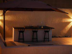 a kitchen island with two bar stools and a sink at O2 pool villa in Ras al Khaimah