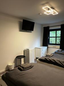 a bedroom with two beds and a flat screen tv at Olymp Wettenberg - Monteurzimmer in Launsbach