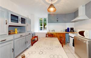 cocina con mesa y cocina con armarios azules en Nice Apartment In Trouvans With Kitchenette, 