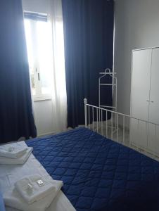 een slaapkamer met een blauw bed en een raam bij Matteo's House Taormina in Taormina