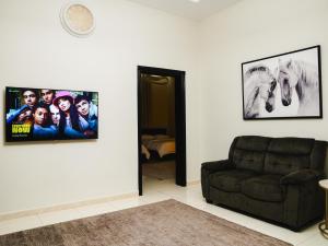 a living room with a couch and posters on the wall at O2 pool villa in Ras al Khaimah