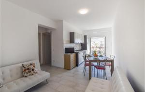 sala de estar con sofá y mesa con sillas en 2 Bedroom Nice Apartment In Nicotera Marina, en Nicotera Marina