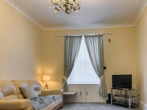 uma sala de estar com um sofá e uma janela em Victorias Haven em Kirkcaldy