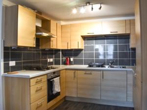 a kitchen with wooden cabinets and a sink at Hammerman Holiday Escape in Aberdeen