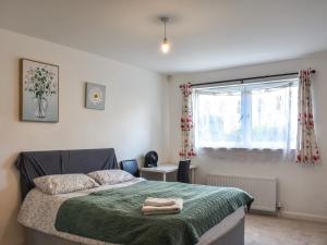 a bedroom with a bed with a green blanket and a window at Hammerman Holiday Escape in Aberdeen