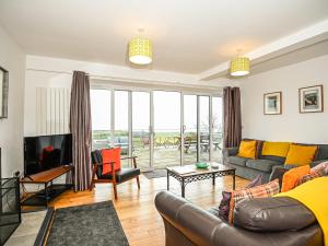 a living room with a couch and a tv at Sgwner View in Abererch