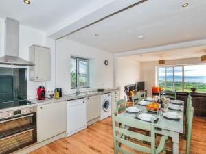 a kitchen with a table with chairs and a dining room at Sgwner View in Abererch