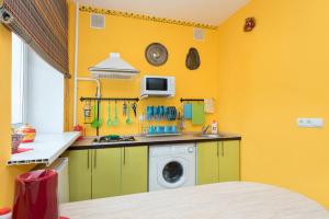 エカテリンブルクにあるСелимВсех на Вайнераの黄色の壁のキッチン、洗濯機が備わります。