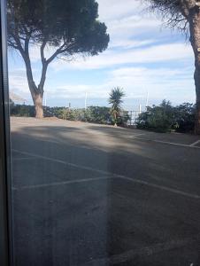 an empty parking lot with trees on the side of the road at Matteo's House Taormina in Taormina