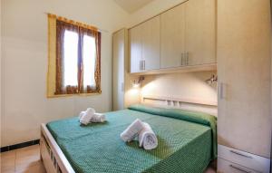 a bedroom with a green bed with towels on it at 1 Bedroom Amazing Apartment In Costa Rei -Ca- in Costa Rei