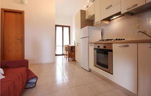 a kitchen with white cabinets and a stove top oven at 1 Bedroom Amazing Apartment In Costa Rei -Ca- in Costa Rei
