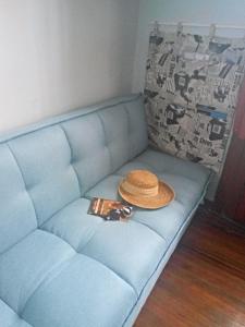 Un sofá azul con sombrero y una botella. en Tu casa en Montevideo, en Montevideo