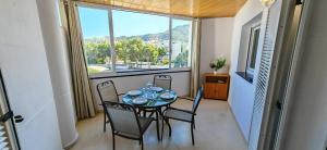 a dining room with a table and chairs and a window at Residencial Aventino en pleno centro del L'Albir in Albir