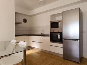 a kitchen with white cabinets and a stainless steel refrigerator at El Yate Sol y Mar in Aguadulce