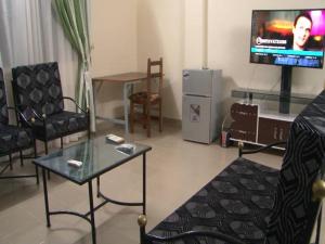 Centre Ecotouristique de Bagré في Saré: غرفة معيشة مع طاولة وتلفزيون