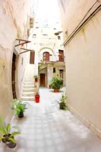 an alley with potted plants and stairs in a building at Il Borgo Trapanese in Trapani