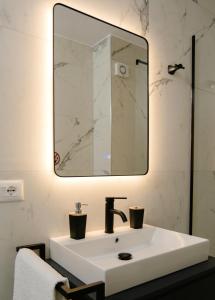 a bathroom with a white sink and a mirror at Urban Serenity City Skyline View Apartment 1 in Tirana +38 photos