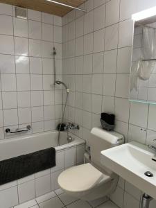 ザンクト・ガレンにあるroom service Joppichの白いバスルーム(トイレ、シンク付)
