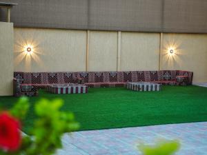 Zimmer mit Stühlen und grünem Rasen in der Unterkunft O2 pool villa in Ras al Khaimah
