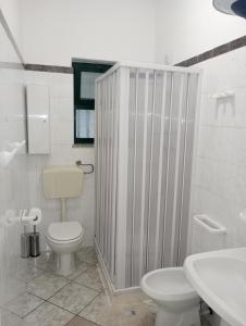 een witte badkamer met een toilet en een wastafel bij Matteo's House Taormina in Taormina