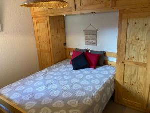 - une chambre avec un lit doté d'oreillers bleus et rouges dans l'établissement Appartement dupleix - 6 personnes - Grand Bornand village, au Grand-Bornand