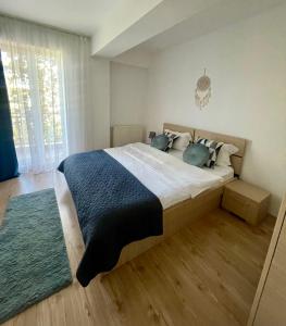 una camera da letto con un grande letto con una coperta blu di Travel Bucharest Airport Residences-SELF CHECK-IN 