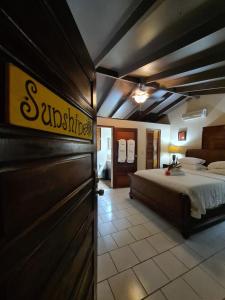 um quarto com uma cama e uma placa na parede em Yocamatsu em Caye Caulker