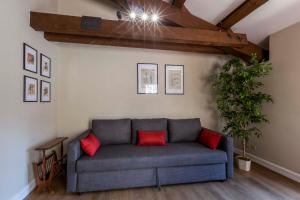 a couch in a living room with red pillows at Casa Tosca con balcone vicino parcheggio in Macerata