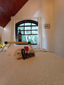 a bed with a towel with the word love on it at Casa da Vovó na Pousada Sitio Pauletto - com Cozinha, Churrasqueira e Decoração in Jarinu +52 photos