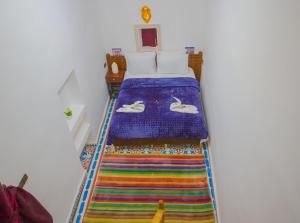 - une chambre avec un lit et une moquette colorée dans l'établissement Fes Hostel Zaouia, à Fès