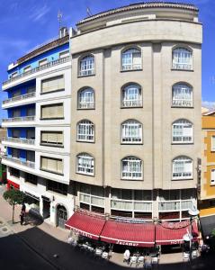 a large building with a red awning in front of it at Hotel Jucamar in Cangas de Morrazo