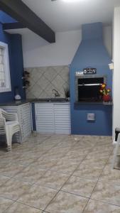 a blue kitchen with a sink and a counter at Triplex 5 min do Jardim Botânico in Curitiba