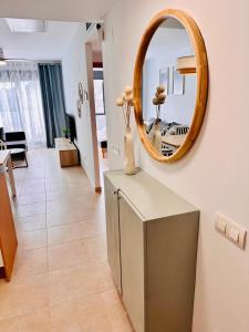 sala de estar con espejo en la pared en Apartamento con Piscina y Jardín Fantástico Cala Sirenas - Nuevo, en Miami Platja