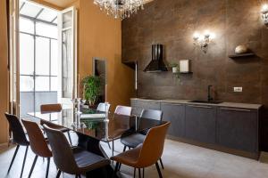 una sala da pranzo con tavolo in vetro e sedie di Heritage Miracle Suite a Roma