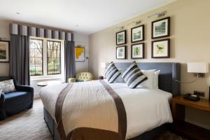 a hotel room with a large bed and a chair at voco Oxford Thames by IHG in Oxford +191 photos