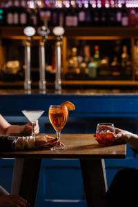 una mesa con dos vasos encima de un bar en voco Oxford Thames, an IHG Hotel, en Oxford