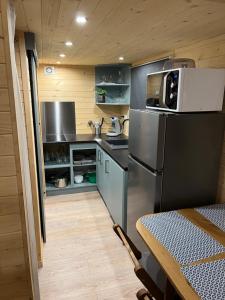 a kitchen with a stainless steel refrigerator and a table at Petit chalet Cosy in Villard-de-Lans