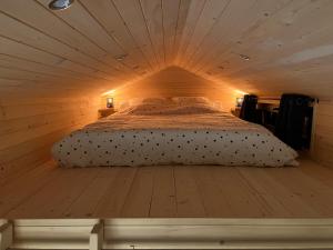 een bed in een houten kamer met een plafond bij Petit chalet Cosy in Villard-de-Lans