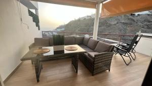a living room with a couch and a table and chairs at Apartments Rachel Paradise in Puerto Rico de Gran Canaria