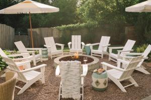 a group of white chairs and a fire pit in a yard at The June Motel in Picton