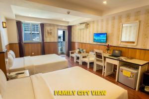 a hotel room with two beds and a desk at Golden Rain 2 Hotel in Nha Trang