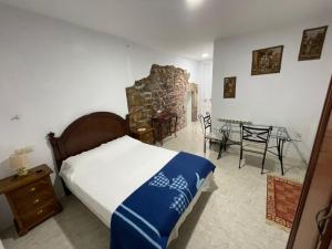 a bedroom with a bed and a table and chairs at Hotel El Nuevo Semellon 