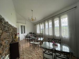 a dining room with tables and chairs and windows at Hotel El Nuevo Semellon 