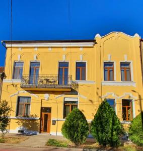 un edificio amarillo con balcón en ORI Classy Apart Malul Mureșului en Arad