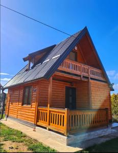 Han Pijesak的住宿－TAMARA - Brvnara za odmor，小木屋设有门廊和屋顶