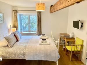 een slaapkamer met een bed, een tafel en een bureau bij Westbury Cross House Bed & Breakfast in Westbury-sub-Mendip