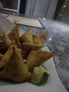 a plate of food with chips and a lime on a counter at Mojoh Inn Hotel in Ambira